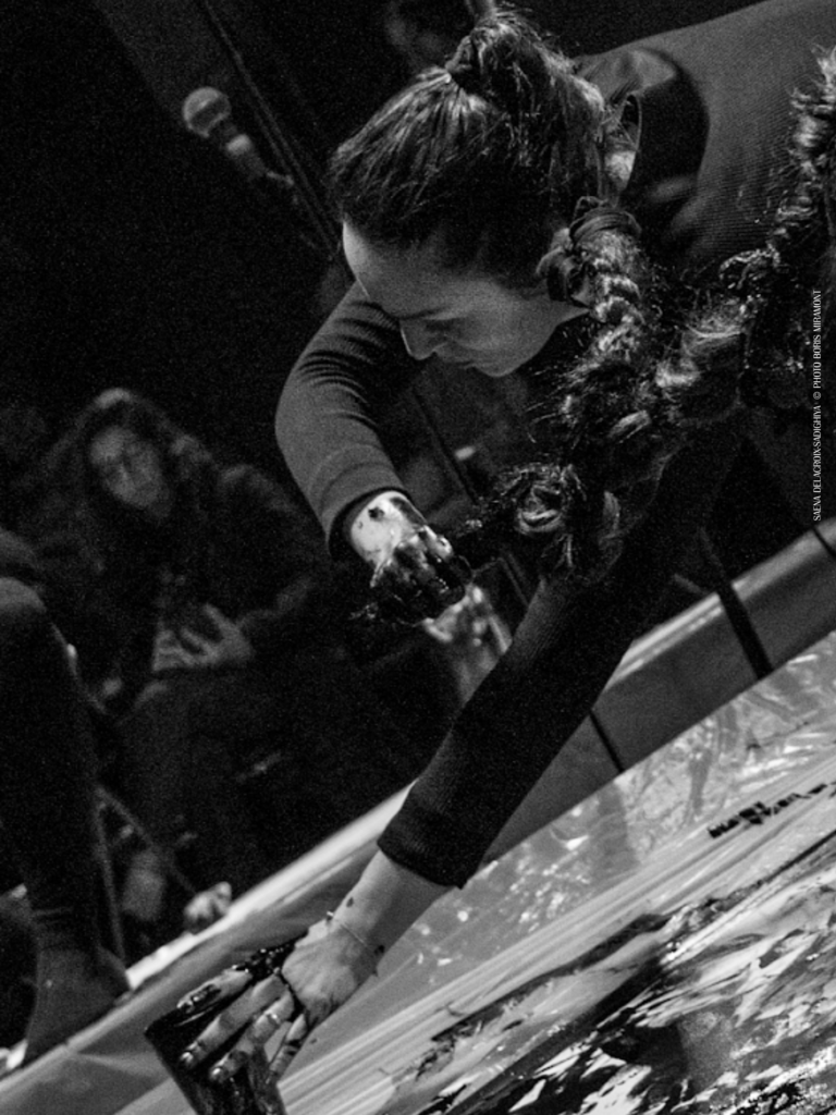 Performance de calligraphie : une artiste trace des signes au sol devant le public